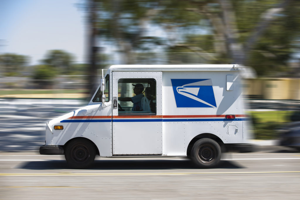Fullerton, California / USA - July 18, 2020: A USPS (United States Parcel Service) mail truck leaves for a delivery.