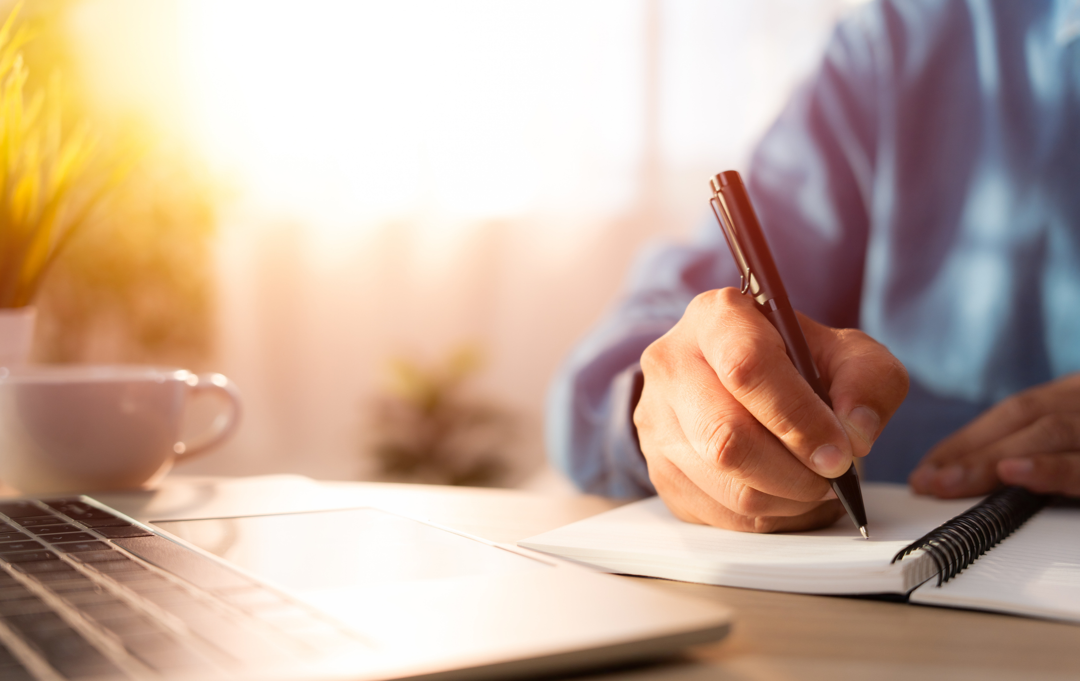 Close-up of man hand using writing pen memo on notebook paper or letter, diary on table desk office. Workplace for student, writer with copy space. business working and learning education concept.
