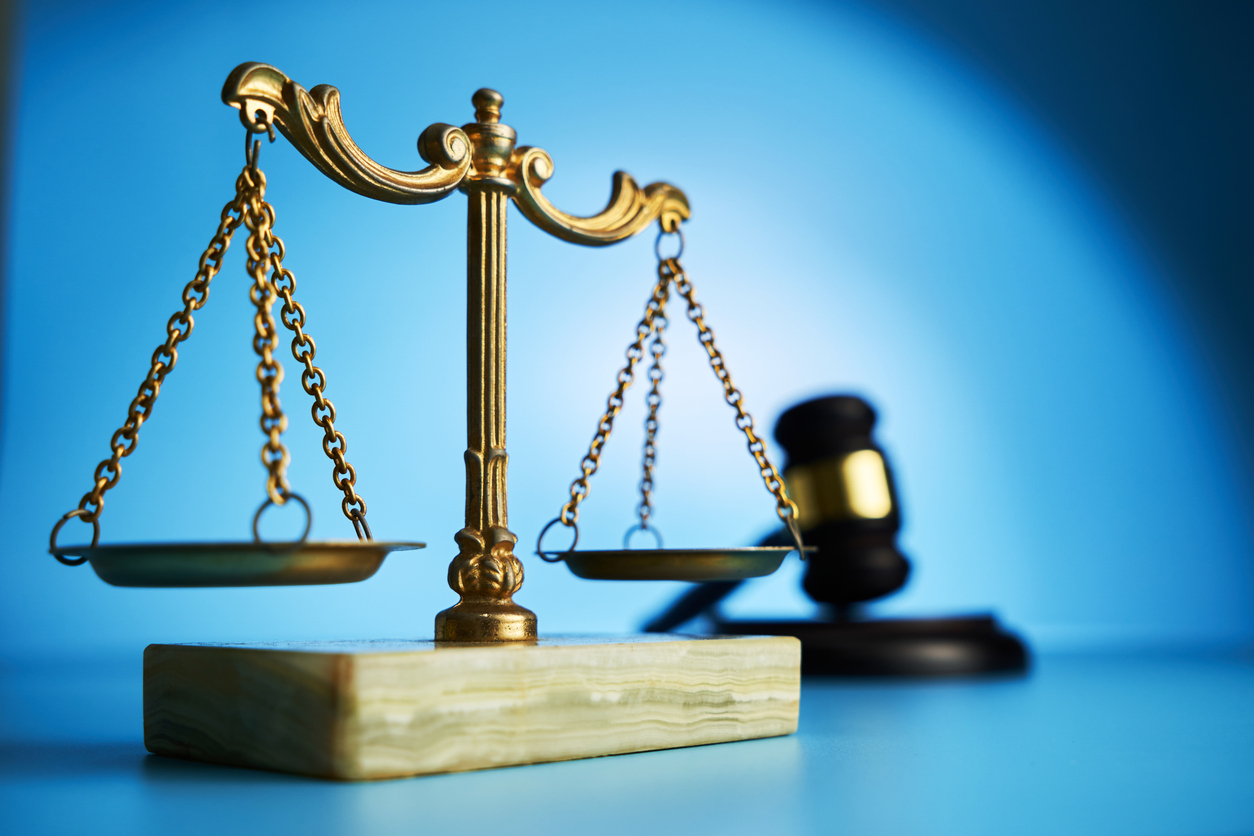 libra scale and gavel hammer on blue background focus on foreground