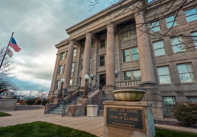 Appellate Court of the State of Illinois Fourth District building with stone columns, staircase entrance, and American fla...