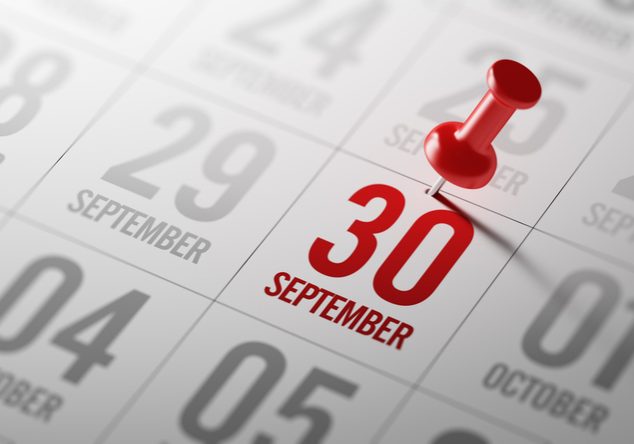 Red pushpin marking September 30 on a white calendar page, with surrounding dates including September 29 and October dates...