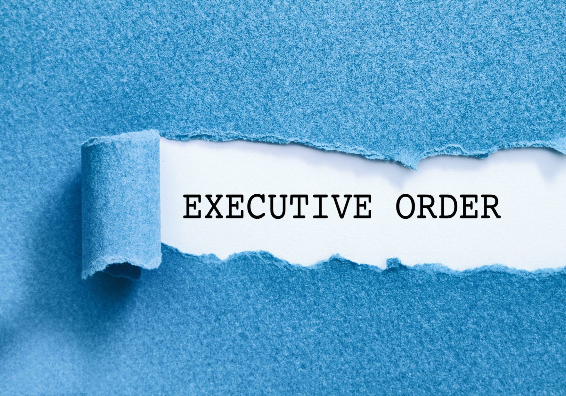 Blue paper torn open revealing white surface underneath with bold text reading EXECUTIVE ORDER