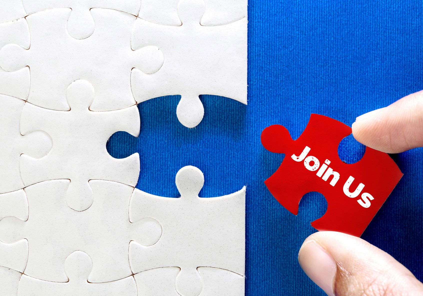 Close up piece of white jigsaw puzzle with Join Us text , concept of business challenge success completion with teamwork